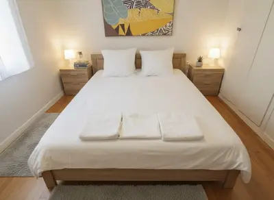 a bedroom with a large white bed with two pillows at Bright 2-Bedroom Apt in Ampelokipoi Near Hospital in Athens