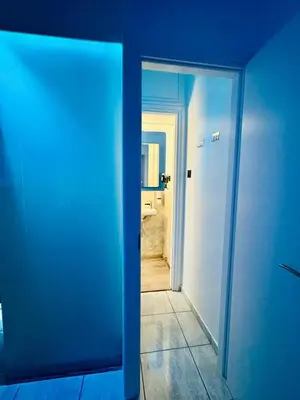 a blue door leading into a room with a bathroom at Hera Luxury Suite by Zeus Suites in Athens