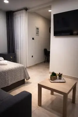 a living room with a bed and a table with a tv at JASMIN Luxury Apartment in Athens