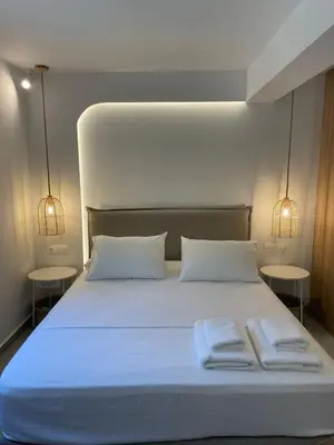 a white bed with two towels on top of it at Voula Lemon Garden by Taurus in Athens