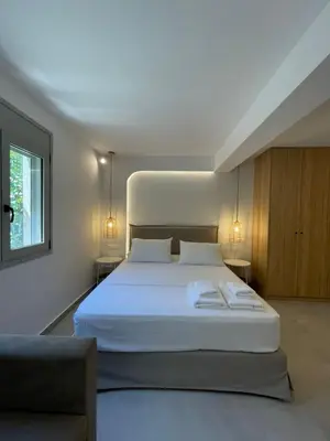 a bedroom with a large white bed and a couch at Voula Lemon Garden by Taurus in Athens