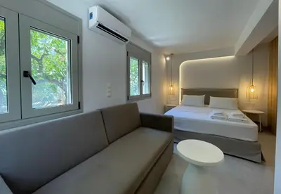 a room with a couch and a bed and a window at Voula Lemon Garden by Taurus in Athens