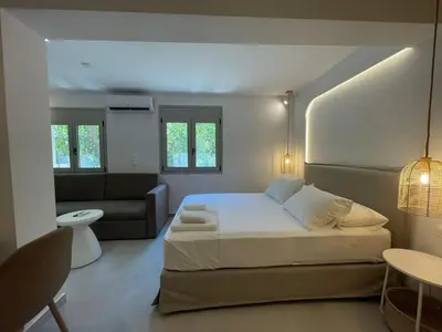 a bedroom with a large bed and a couch at Voula Lemon Garden by Taurus in Athens