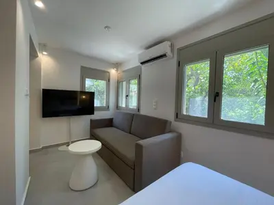 a living room with a couch and a flat screen tv at Voula Lemon Garden by Taurus in Athens