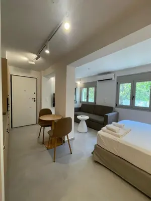 a bedroom with a bed and a couch and a table at Voula Lemon Garden by Taurus in Athens