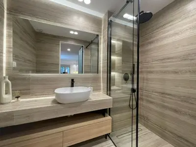 a bathroom with a sink and a glass shower at Voula Olive Garden by Taurus in Athens