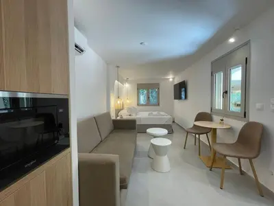 a living room with a couch and a room with a bed at Voula Olive Garden by Taurus in Athens