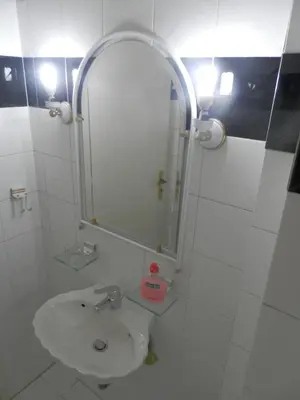 a white bathroom with a sink and a mirror at Comfortable apartment by the Metro in Athens