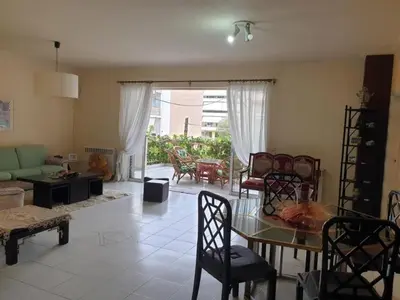 a living room with a table and chairs at Comfortable apartment by the Metro in Athens