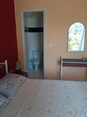 a bedroom with a bed and a bathroom with a toilet at Comfortable apartment by the Metro in Athens