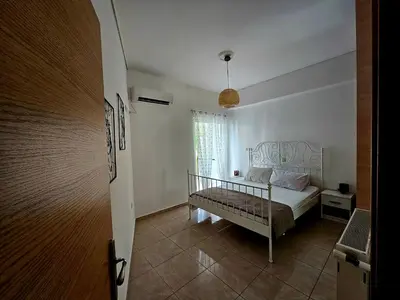 a white bedroom with a bed and a window at Scooby's Spot in Athens