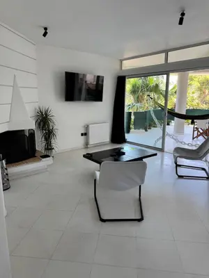 a living room with a black table and chairs at Oasis 3 minutes from the beach in Vari