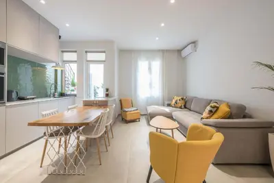a kitchen and living room with a couch and a table at Modern 1BR in Exarchia l Green-View Balcony in Athens