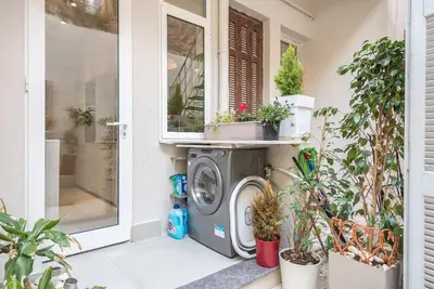 a washing machine outside a house with potted plants at Modern 1BR in Exarchia l Green-View Balcony in Athens
