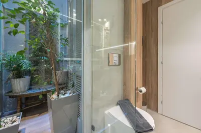 a bathroom with a glass shower with potted plants at Modern 1BR in Exarchia l Green-View Balcony in Athens