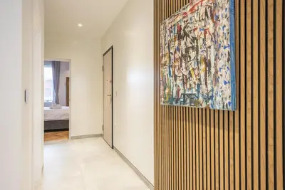 a hallway with a large painting on the wall at Modern 1BR in Exarchia l Green-View Balcony in Athens