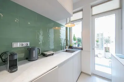 a kitchen with green walls and a sink and a window at Modern 1BR in Exarchia l Green-View Balcony in Athens