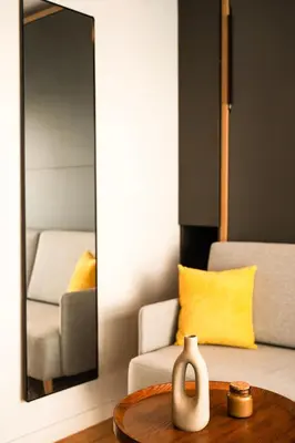a mirror in a living room with a vase on a table at Kali 56 in Athens