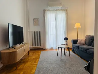 a living room with a couch and a flat screen tv at Arisa Apartment in Athens next to Metro Station in Athens