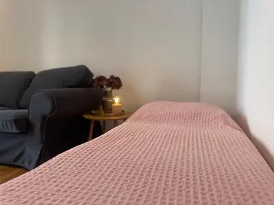 a bed with a pink comforter and a couch at Arisa Apartment in Athens next to Metro Station in Athens