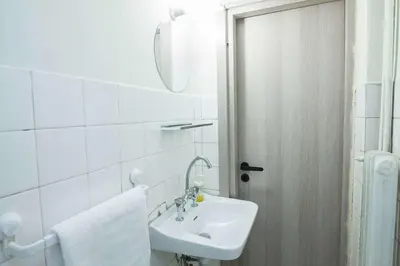 a white bathroom with a sink and a mirror at Cozy Minimal Studio by Ampelokipoi Metro in Athens