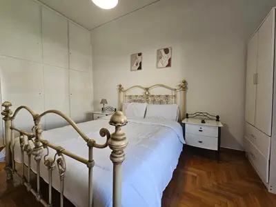 a bedroom with a large bed and a dresser and a bed sidx sidx sidx at Come & Stay Apartment - Athens Town in Athens