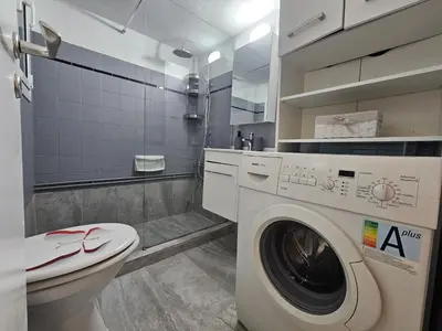 a bathroom with a washing machine and a toilet at Come & Stay Apartment - Athens Town in Athens