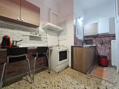 a kitchen with a stove and some chairs in it at Come & Stay Apartment - Athens Town in Athens