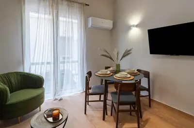 a living room with a table and a green couch at Classic & Charming 2BR, Petralona Metro in Athens