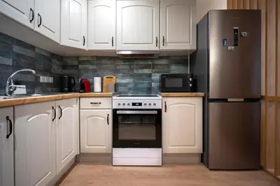 a kitchen with white cabinets and a refrigerator at Classic & Charming 2BR, Petralona Metro in Athens