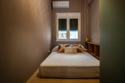 a bedroom with a large bed with a window at Classic & Charming 2BR, Petralona Metro in Athens
