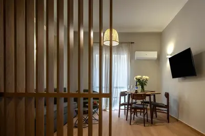 a dining room with a table with chairs and a television at Classic & Charming 2BR, Petralona Metro in Athens