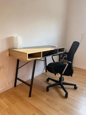 an office desk with a black chair and a wooden table at Cozy Urban Retreat in Athens