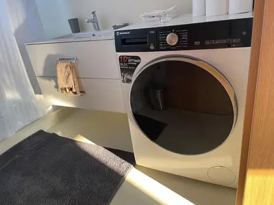 a washing machine in a kitchen with a sink at Cozy Urban Retreat in Athens