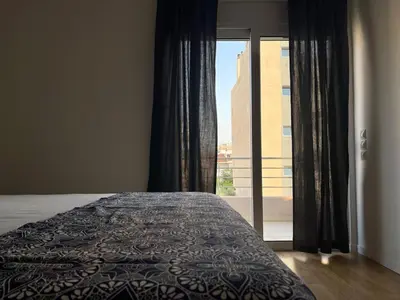 a bedroom with a bed and a large window at Cozy Urban Retreat in Athens