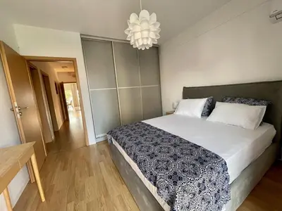 a bedroom with a large bed and a chandelier at Cozy Urban Retreat in Athens