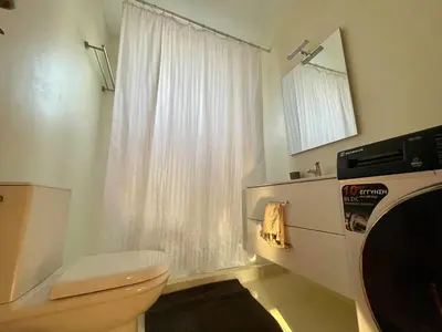 a bathroom with a white toilet and a window at Cozy Urban Retreat in Athens