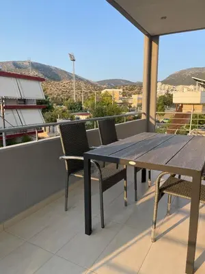 a wooden table and chairs on a balcony at Cozy Urban Retreat in Athens