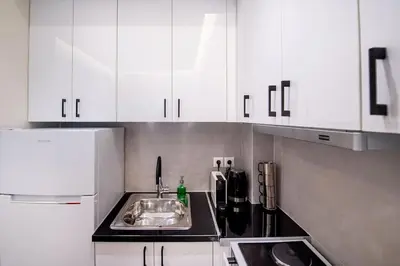 a kitchen with a sink and white cabinets at Stylish Apartment-Κέντρο Αθήνα-15' περπάτημα από την Ακρόπολη in Athens