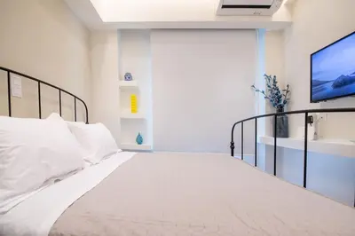 a bedroom with a white bed and a tv at Stylish Apartment-Κέντρο Αθήνα-15' περπάτημα από την Ακρόπολη in Athens