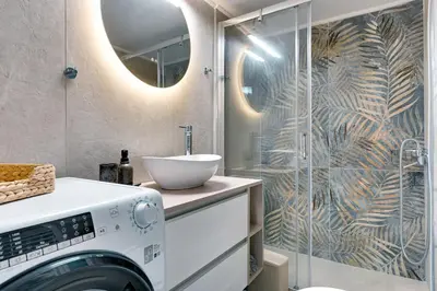 a bathroom with a washing machine and a shower at Lovely Goudi Apartment - Perfect Athens Getaway in Athens
