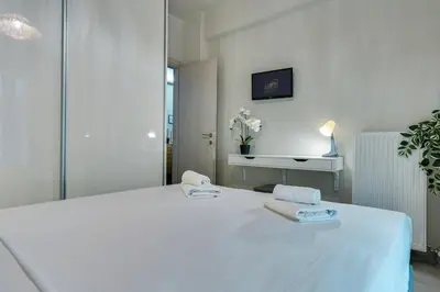 a bedroom with a white bed with two towels on it at Lovely Goudi Apartment - Perfect Athens Getaway in Athens