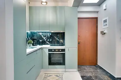 a kitchen with blue cabinets and a wooden door at Lovely Goudi Apartment - Perfect Athens Getaway in Athens