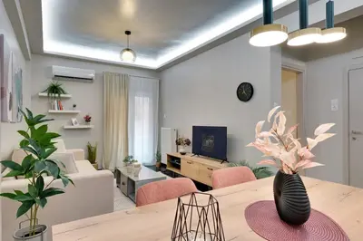 a living room with a dining table and a living room with a couch at Lovely Goudi Apartment - Perfect Athens Getaway in Athens