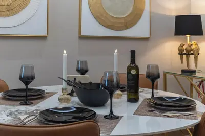 a dining room table with a bottle of wine and glasses at Acropolis view luxury apartment in Athens