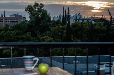 a cup of coffee sitting on a table on a balcony at Acropolis view luxury apartment in Athens