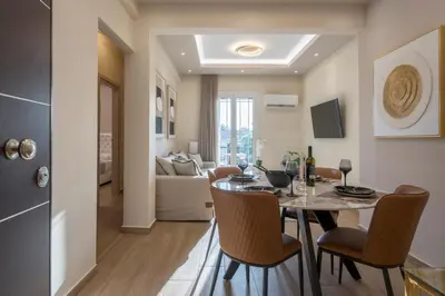 a dining room and living room with a table and chairs at Acropolis view luxury apartment in Athens