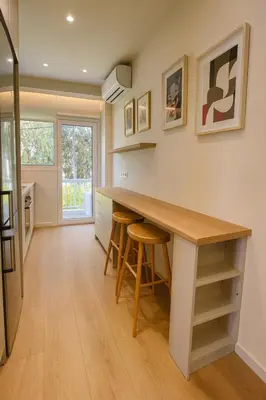 a kitchen with a counter with stools and a table at Chic Athenian Apartment by the Riviera in Athens