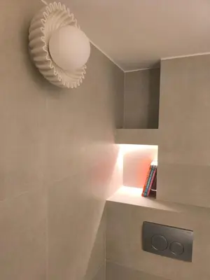 a bathroom with a light fixture on the wall at Chic Athenian Apartment by the Riviera in Athens