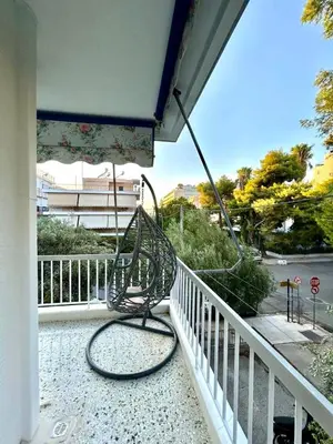 a bench sitting on a balcony with a fence at Chic Athenian Apartment by the Riviera in Athens
